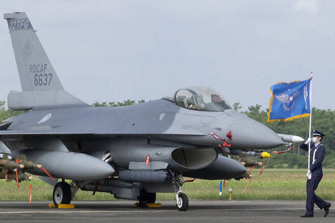 18일 대만 서남부 자이현 공군기지에 F-16V 개량형 전투기가 주기된 가운데 한 군인이 공군기를 든 채 그 앞을 지나고 있다. AP 연합뉴스
