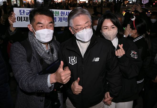 이재명 더불어민주당 대선후보와 부인 김혜경씨가 11월18일 서울 고척스카이돔에서 열린 KT 위즈와 두산 베어 스의 한국시리즈 4차전을 찾아 입장하기 전 시민들과 기념촬영을 하고 있다.ⓒ시사저널 국회사진 취재단