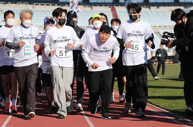 근육 긴장 이상증을 앓고 있는 국민 마라토너 이봉주씨가 2021년 11월 28일 부천종합운동장에서 열린 '이봉주 쾌유 기원 마라톤'에 참가해 페이스메이커들과 결승선을 향해 달리고 있다. 이봉주씨는 마지막 1.2㎞ 구간을 뛰어 결승선을 통과했다./이덕훈 기자