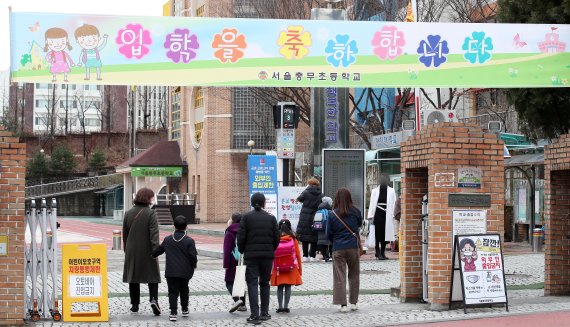 행정안전부와 교육부는 내달 3일부터 2022학년도 취학아동을 대상으로 취학통지서 온라인발급 서비스를 개시한다. 사진은 지난해 3월 서울의 한 초등학교 입학식에 참석하기 위해 부모와 아이들이 등교하는 모습. 뉴스1