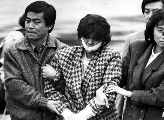 1987년 12월 15일 안기부 직원에 의해 김포공항에서 연행되는 김현희(당시 하치야 마유미). 1987. 12 15. 한국일보 자료사진
