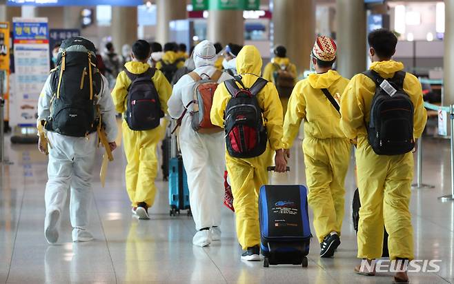 [인천공항=뉴시스] 배훈식 기자 = 코로나19 변이 바이러스 오미크론 유입 차단을 위해 남아공 등 8개국 발 외국인 입국이 제한된 29일 오전 인천국제공항 제1터미널에서 방호복을 착용하고 입국한 외국인들이 이동하고 있다. 2021.11.29. dahora83@newsis.com