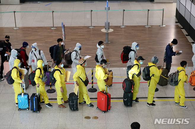 [인천공항=뉴시스] 배훈식 기자 = 코로나19 변이 바이러스 오미크론 유입 차단을 위해 남아공 등 8개국 발 외국인 입국이 제한된 29일 오전 인천국제공항 제1터미널에서 방호복을 착용하고 입국한 외국인들이 행선지 이동 수단 등을 확인하기 위해 대기하고 있다. 2021.11.29. dahora83@newsis.com