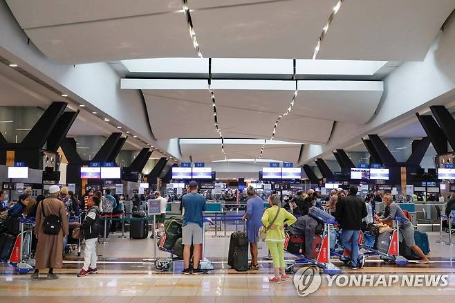 27일(현지시간) 남아공 요하네스버그국제공항에서 대기 중인 여행객들. [AFP 연합뉴스 자료사진. 재판매 및 DB 금지.]