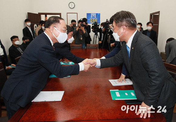 윤호중(오른쪽) 더불어민주당 원내대표와 홍남기 경제부총리 겸 기획재정부 장관이 30일 서울 여의도 국회에서 열린 예산협의에서 악수하고 있다. [사진=김성진 기자]