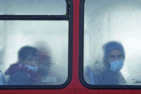 지난 25일(현지시간) 영국 켄트주 도버항 인근에서 난민으로 추정되는 사람들이 버스를 타고 이동하고 있다. [AP=연합뉴스]
