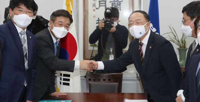 홍남기(오른쪽) 부총리와 윤호중 더불어민주당 원내대표가 30일 국회 민주당 원내대표실에서 예산협의를 위해 만나 악수하고 있다. 국회사진기자단