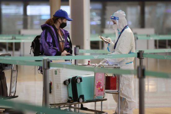지난달 30일 오전 인천국제공항 탑승수속장에서 방호복을 입은 관계자가 발열체크와 백신 접종 증명서를 확인하고 있다. [이미지출처=연합뉴스]