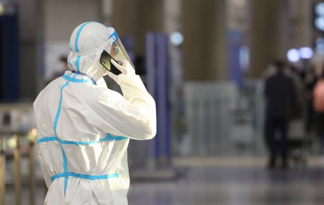 1일 인천공항에서 방역복을 입은 관계자가 통화하고 있다.  / 사진=연합뉴스