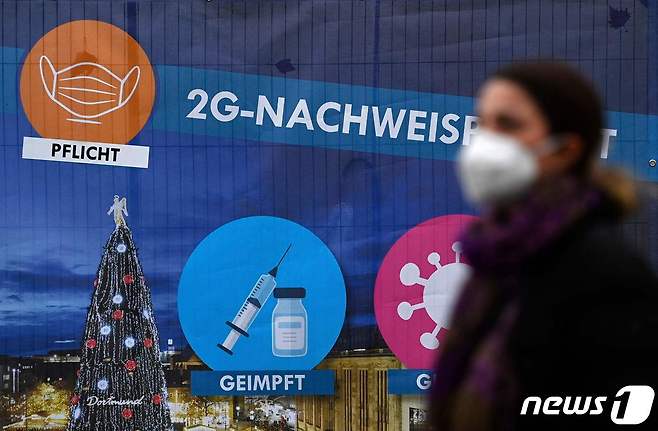 1일(현지시간) 독일 서부 노르트라인베스트팔렌주 도르트문트 거리에 크리스마스 시장을 위해 이른바 '2G' 규정에 대한 현수막이 걸려있다. 2G 규정은 백신 완전접종자와 신종 코로나바이러스 감염증(코로나19) 완치자만 활동 제약을 받지 않는다는 독일의 새로운 방역 조치다. © AFP=뉴스1 © News1 정윤미 기자