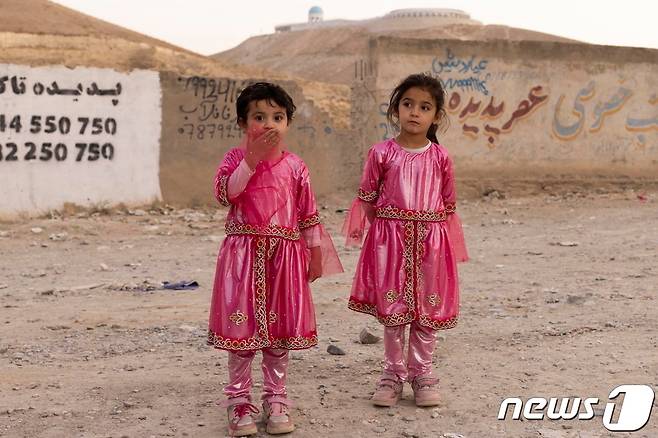 아프가니스탄 카불 외곽 한 동네에서 2021년 10월20일 전통 복장을 입은 여아들이 카메라 앞에서 포즈를 취하고 있다. © 로이터=뉴스1 © News1 최서윤 기자