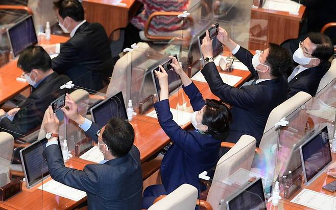 더불어민주당 의원들이 3일 서울 여의도 국회 본회의장에서 자신의 휴대폰으로 본회의를 촬영하고 있다. 국회는 이날 607조 6633억원 규모의 내년도 예산을 처리했다. / 사진제공=뉴시스