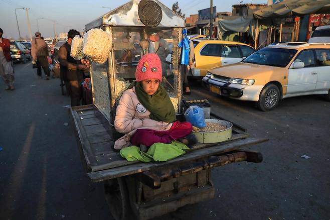 30일(현지시간) 아프가니스탄 수도 카불의 거리에서 팝콘 행상으로 나선 소녀가 손님을 기다리고 있다. 연합뉴스