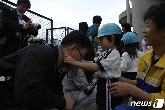 일본 시가조선초급학교 유치반 학생들이 지난 2007년 4월21일 한국에서 온 노래패 '우리나라' 등 일행에게 종이 목걸이를 걸어주고 있다. © 뉴스1