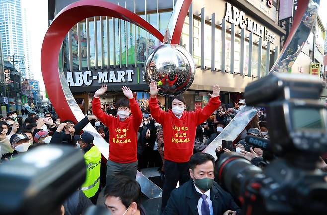 국민의힘 윤석열 대선후보와 이준석 대표가 4일 오후 부산 서면 젊음의 거리에서 커플 후드티를 입고 시민들에게 인사하고 있다. /연합뉴스