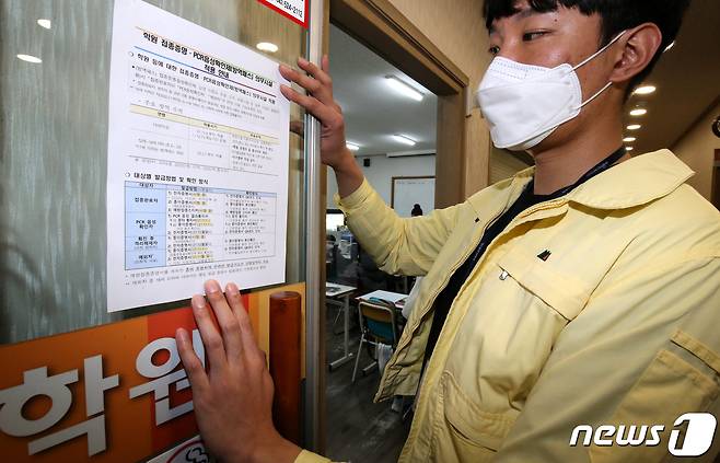 6일 오후 대전에 위치한 학원에서 대전교육청 관계자들이 방역패스 관련 안내문을 붙이고 있다. 2021.12.6/뉴스1 © News1 김기태 기자