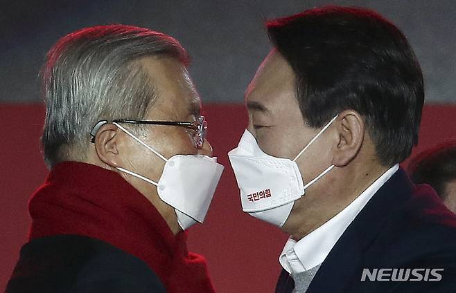 [서울=뉴시스] 국회사진기자단 = 윤석열 국민의힘 대선 후보가 6일 오후 서울 송파구 올림픽공원 체조경기장에서 열린 국민의힘 제20대 대통령선거 중앙선거대책위원회 출범식에서 김종인 총괄선대위원장에게 대선 승리를 기원하는 빨간색 목도리를 둘러준 뒤 포옹을 하고 있다. 2021.12.06. photo@newsis.com