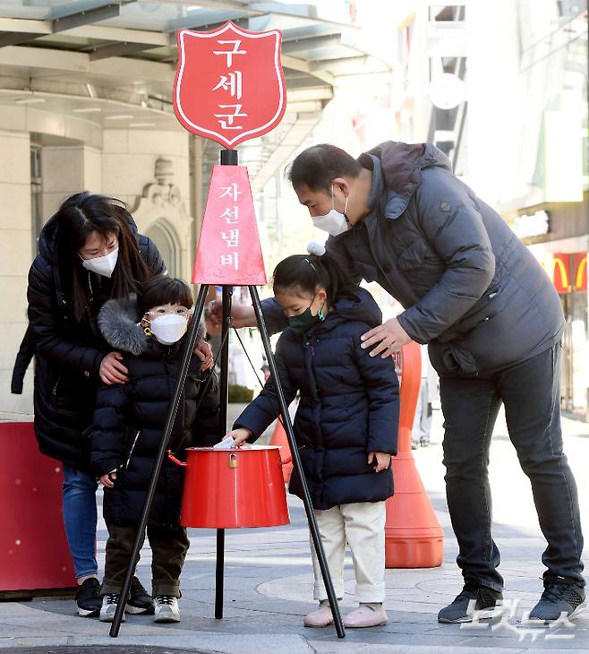 구세군 모금활동이 본격적으로 시작된 1일 오후 서울 명동거리에서 한 가족이 구세군 냄비에 성금을 기부하고 있다. 황진환 기자