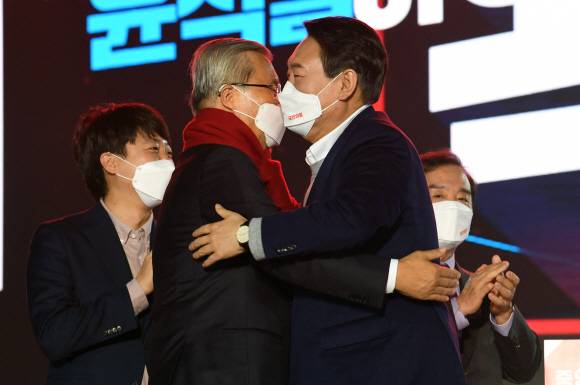 윤석열 국민의힘 대선후보가 6일 서울 송파구 올림픽경기장 케이스포(KSPO)에서 열린 선거대책위원회 출범식에서 김종인 총괄선대위원장에게 빨간색 목도리를 둘러 주며 가볍게 포옹하고 있다. 왼쪽부터 이준석 대표, 김 총괄선대위원장, 윤 후보, 김병준 공동상임선대위원장.김명국 선임기자 daunso@seoul.co.kr