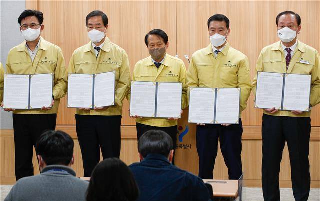 서울시구청장협의회 회장인 이성(왼쪽 세 번째) 구로구청장을 비롯한 협의회 소속 구청장들이 7일 서울시청 브리핑룸에서 기자회견을 열고 ‘권위주의 시대로 돌아가는 서울시에 대한 서울시 구청장 일동의 입장’을 밝힌 뒤 입장문을 들어 보이고 있다.뉴스1