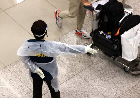 오미크론에 격리조치 강화 - 코로나19의 새로운 변이인 오미크론 확산 여파와 국내 입국자 격리 조치 시행으로 간신히 열렸던 하늘길이 다시 막히고 있다. 에어서울, 제주항공 등 국내 항공사들은 인천~괌 노선 재운항 일자를 연기하거나 예정된 운항을 취소하고 있다. 5일 오후 영종도 인천국제공항 입국장에 방역 관계자가 안내를 하고 있다. 2021.12.5 연합뉴스