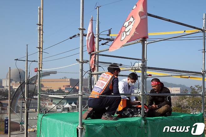 8일 오후 전남 영광군 한국수력원자력 한빛원자력본부 앞에서 임금 인상 등을 요구하며 37일째 철탑 위에서 고공 농성 중인 조합원이 지역 의사에게 건강검진을 받고 있다. 2021.12.8/뉴스1 © News1 황희규 기자