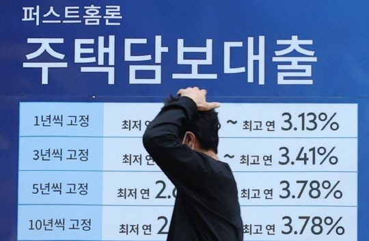 한 시민이 주택담보대출 안내가 걸린 은행 앞을 지나가고 있다. 연합뉴스