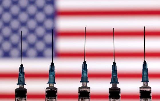 미국 국기 앞에 바늘이 달린 주사기가 놓인 모습. [로이터=연합뉴스]