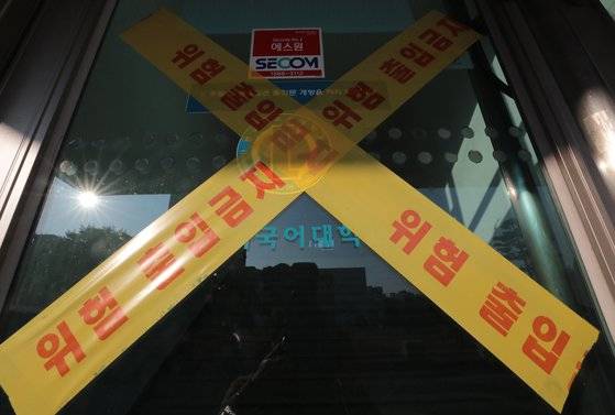 서울에서 신종 코로나바이러스 감염증(코로나19) 오미크론 변이 확진자가 처음 발생했다. 7일 서울시에 따르면 한국외대, 경희대, 서울대에 재학 중인 외국인 유학생 3명이 오미크론 변이에 감염된 것으로 파악됐다. 이에 한국외대는 11일까지 해당 유학생의 동선에 포함된 도서관 등을 제한적으로 운영하며, 14일까지 모든 수업을 비대면 방식으로 전환한다. 7일 서울 동대문구 한국외국어대학교 서울캠퍼스의 한 건물이 통제되고 있다. 뉴스1