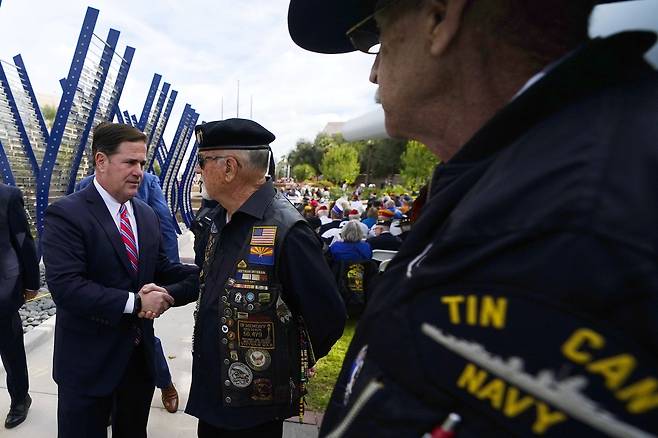 더그 듀시 애리조나 주지사가 7일 애리조나 피닉스의 USS 애리조나함 기념관에서 열린 진주만 공습 80주년 기념행사에 참석해 참전 노병들과 악수하고 있다. 피닉스에는 진주만 공습당시 침몰한 USS 애리조나 함을 기억하는 기념관이 있다. AP=연합뉴스