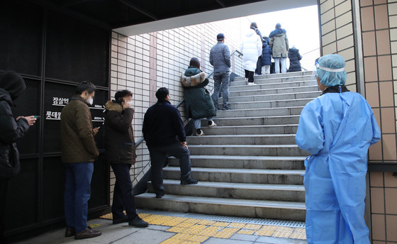 People stand in line to receive tests at a Covid-19 testing station in Songpa District, southern Seoul, on Wednesday. [YONHAP]