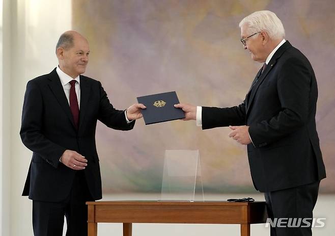 [AP/뉴시스] 올라프 숄츠 독일 새 총리(왼쪽)가 8일 연방의회서  총리로 선출된 뒤 대통령궁을 찾아 슈타인마이어 대통령으로부터 임명의 서한을 받고 있다