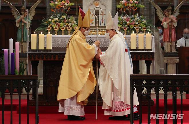 [서울=뉴시스] 사진공동취재단 = 염수경(오른쪽) 추기경이 8일 오후 서울 중구 명동대성당에서 천주교 서울대교구장에 취임하는 정순택 대주교에게 주교의 품위와 권할권을 상징하는 지팡이 목장을 전달하고 있다. 2021.12.08. photo@newsis.com