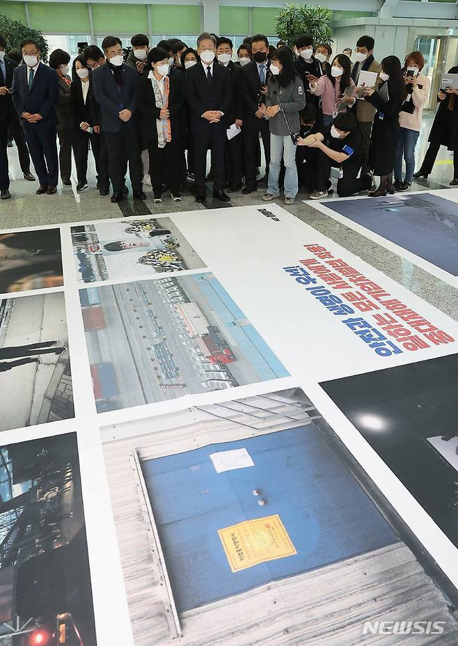 [서울=뉴시스] 최동준 기자 = 이재명 더불어민주당 대선 후보가 8일 서울 여의도 국회 의원회관에서 고 김용균 3주기 추모 사진전을 관람하고 있다. (공동취재사진) 2021.12.08. photo@newsis.com