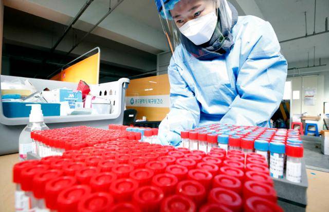 코로나19 일일 확진자가 이틀 연속 7,000명을 넘어선 9일 광주 북구 선별진료소에서 의료진이 수거한 검체 통의 수량을 확인하고 있다. 광주 북구청 제공