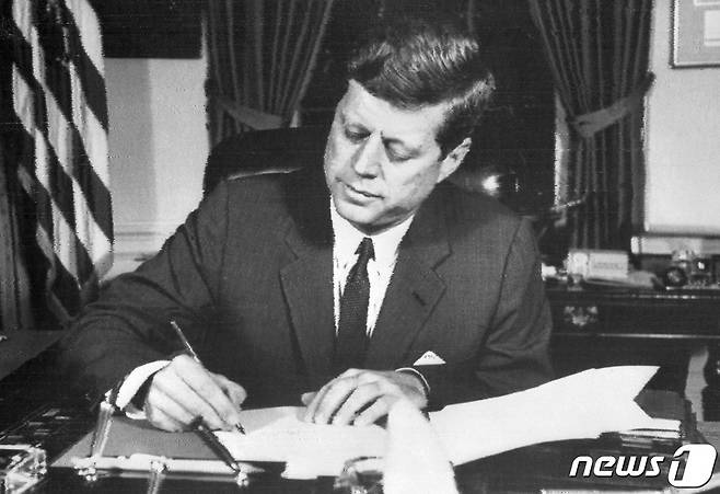 존 F. 케네디 미국 대통령이 쿠바 미사일 위기 중에 워싱턴 D.C 백악관에서 쿠바 해상 봉쇄 명령에 서명하고 있다. 1962.10.24 © AFP=뉴스1