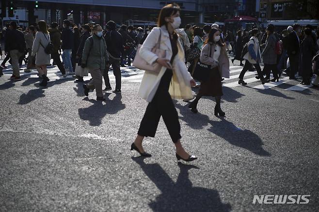 [도쿄=AP/뉴시스] 10일 일본 도쿄의 시부야 쇼핑가에서 마스크를 쓴 시민들이 교차로를 건너고 있다. 일본에서 8명의 코로나19 오미크론 변이 감염자가 확인돼 오미크론 감염자 수는 총 12명으로 늘었다. 2021.12.10