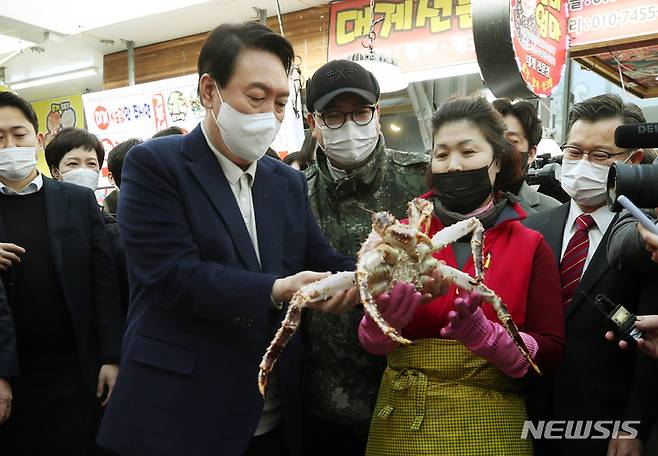 [속초=뉴시스] 전신 기자 = 윤석열 국민의힘 대선 후보가 11일 강원도 속초 대포항 수산시장을 방문해 킹크랩을 살펴보고 있다. 2021.12.11. photo1006@newsis.com