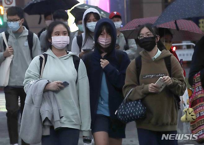 [타이베이=AP/뉴시스] 대만 수도 타이베이에서 지난달 30일 코로나19 예방을 위해 마스크를 착용한 시민들이 시내 거리를 걷고 있다. 2021.12.11.