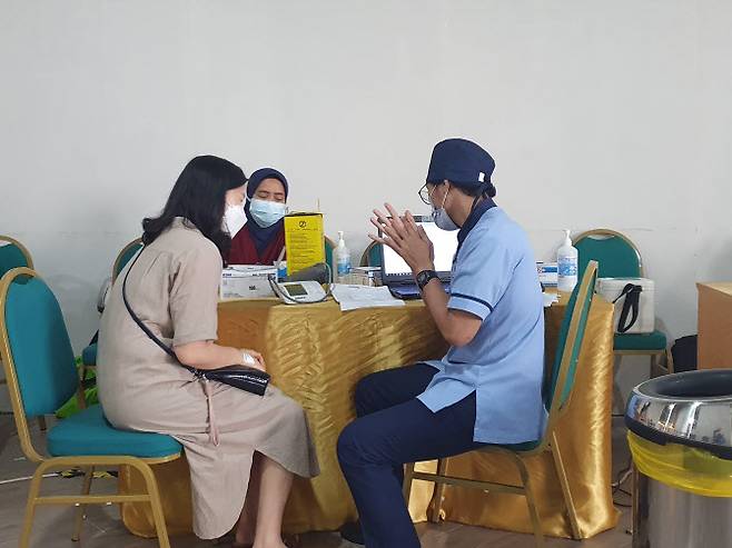 인도네시아 남부 자카르타 끄망 리뽀몰에 설치된 백신 접종소에서 교민이 아스트라제네카(AZ) 백신 접종을 위한 설명을 듣고 있다(사진=연합뉴스)