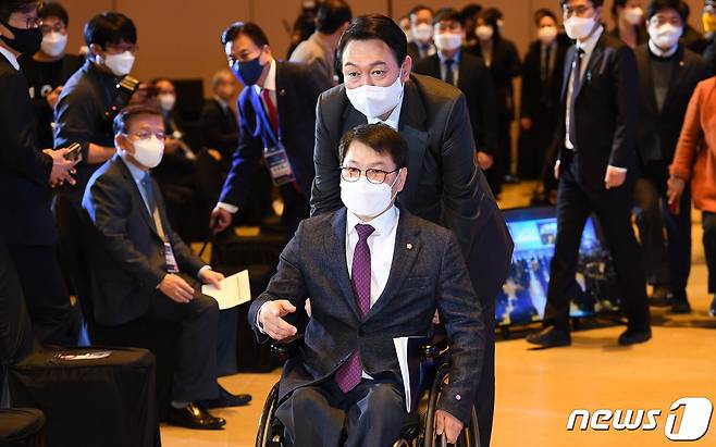 국민의힘 윤석열 대선 후보가 10일 서울 강남구 코엑스에서 열린 사회복지비전선포대회에서 국민의힘 이종성 의원의 휠체어를 밀며 함께 입장하고 있다. 2021.12.10/뉴스1