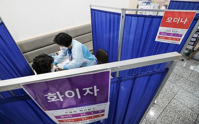 정부가 연일 악화하는 코로나19 유행 상황을 억제하기 위해 백신 3차 접종 간격을 3개월까지 단축하기로 한 10일 오후 서울 서대문구 동신병원 예방접종센터에서 의료진이 화이자 백신으로 추가접종(부스터 샷)을 하고 있다./연합뉴스