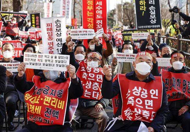 지난 8일 서울 국회의사당 인근에서 열린 ‘코로나 피해 실질 보상 촉구 정부 여당 규탄대회’에 참가한 코로나 피해 자영업 총연합 회원들이 실질적인 손실보상 및 집합제한 명령 전면 해제 등을 촉구하는 내용의 손 피켓을 들고 있다. 연합뉴스