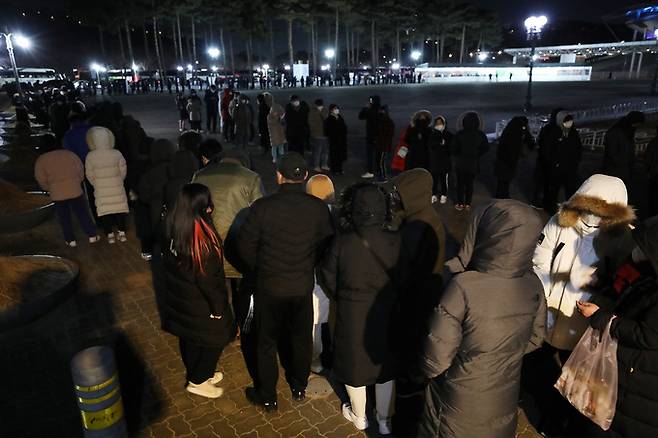 12일 저녁 서울 마포구 상암동 월드컵 공원 내 평화광장에 마련된 임시 선별진료소를 찾은 시민들이 신종 코로나바이러스 감염증(코로나19) 진단검사를 받기 위해 길게 줄지어 서 있다. 뉴스1
