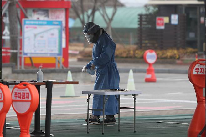 12일 오전 전남 함평군 함평읍 함평엑스포공원 주차장에 마련된 임시 선별진료소에서 방역 공무원이 소독약을 뿌리고 있다. 함평군은 지역 내에서 오미크론 변이 의심 확진자가 10여 명 발생하자 연쇄(n차) 접촉자들의 전수검사를 위해 임시 선별진료소를 운영했다. 2021.12.12 연합뉴스