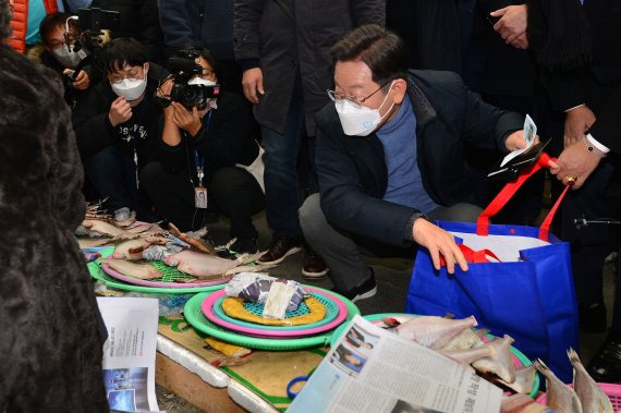 포항 죽도시장 방문한 이재명 이재명 더불어민주당 대선 후보가 3박4일간 대구·경북지역 유세 마지막 날인 13일 경북 포항시 죽도시장에서 건어물을 구입하고 있다. 뉴스1