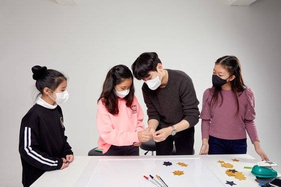 이영규(왼쪽에서 셋째) 파티플래너가 이효주(왼쪽에서 둘째) 학생모델에게 포토 프레임을 꾸밀 때 쓰는 도구 사용법을 알려주고 있다.