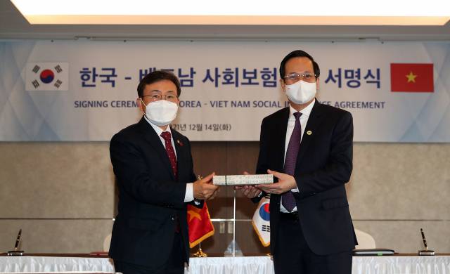 권덕철(왼쪽) 보건복지부 장관이 14일 다오 응옥 중 베트남 노동보훈사회부 장관과 서울의 한 호텔에서 ‘양국 정부 간 사회보험에 관한 협정’에 서명한 뒤 기념사진을 촬영하고 있다.