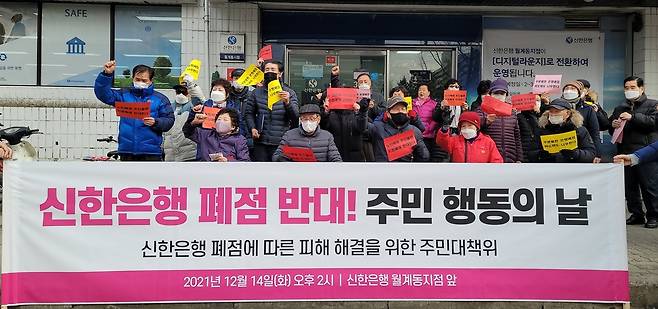 14일 오후 신한은행 월계동지점 앞에 모여 폐점반대 구호를 외치는 주민들. [촬영 조다운]