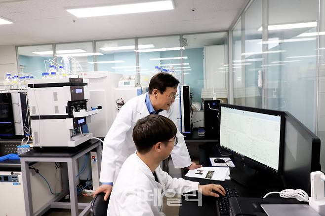 정재준 아리바이오 대표가 한 연구원과 신약후보 물질의 평가 결과에 대해 이야기하고 있다.(제공=아리바이오)